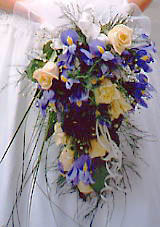 Farbenfrohe Blüten auf dem weissen Brautkleid